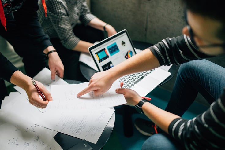 Image of laptop collaboration with paper